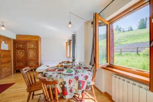 a dining room with a table and a window at Studio Clotes Ski In - Ski Out - Happy Rentals in Sauze dʼOulx