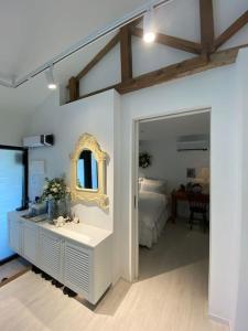 a bathroom with a sink and a bedroom with a bed at Gonae Reborn in Jeju