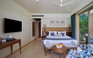 a hotel room with a bed and a tv at Marquis Beach Resort in Candolim