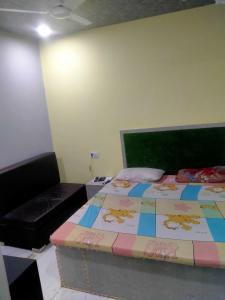 Bhiwāni的住宿－OYO Hotel Panchtara，一间卧室配有一张床和一张沙发