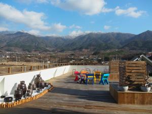 a wooden deck with colorful chairs and tables on a roof at Nogodan Guesthouse and Hotel in Gurye