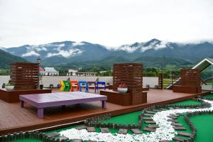 a rooftop deck with a table and chairs and mountains at Nogodan Guesthouse and Hotel in Gurye
