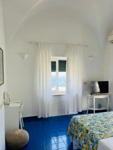 a bedroom with a bed and a window and a table at B&B L'Agapanto in Capri +37 photos