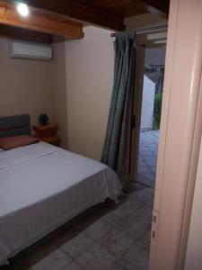 ein Schlafzimmer mit einem Bett und einer offenen Tür in der Unterkunft Alex 2 Bedroom Apartment in Planos