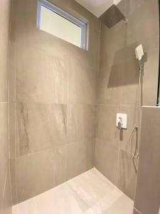 a bathroom with a shower with a glass door at Monde Residence I no 6 Batam Centre in Sengkuang