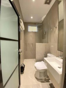 La salle de bains est pourvue de toilettes et d'un lavabo. dans l'établissement Monde Residence I no 6 Batam Centre, à Sengkuang