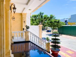 een huis met een reflectie in een zwembad van water bij Khách sạn Miami Ninh Thuận in Phan Rang