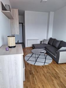Una sala de estar con un sofá negro y una mesa. en Apartman Mia 2 Banja Luka, en Banja Luka 4 fotos más