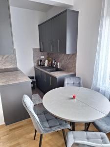 Un comedor con una mesa y sillas blancas. en Apartman Mia 2 Banja Luka, en Banja Luka