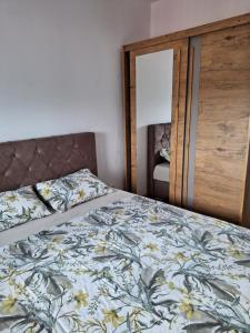 Un dormitorio con una cama con una colcha floral. en Apartman Mia 2 Banja Luka, en Banja Luka