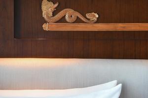 a wooden wall with a dragon above a bed at Le Meridien Jakarta in Jakarta