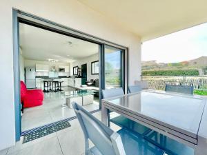 - un salon avec une table et des chaises en verre dans l'établissement VUE MER 180°, TERRASSE, CLIM, à Propriano