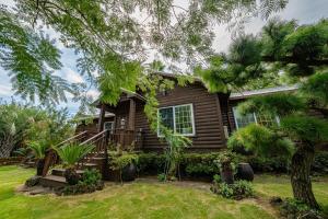 a log cabin with a porch and a yard at Valley Village in Seogwipo