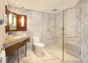 a bathroom with a shower and a toilet and a sink at Le Meridien Jakarta in Jakarta