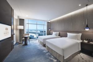 Krevet ili kreveti u jedinici u objektu Grand Barony Qingdao Airport Hotel