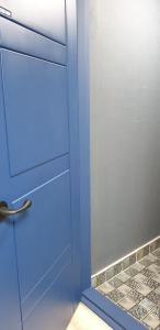 una porta blu con specchio in bagno di Blue Backpackers Hostel a Busan