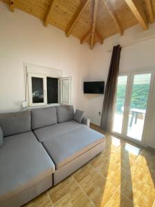 a white couch in a living room with windows at Babis Apartment Agios Nikitas in Agios Nikitas