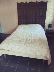 1 dormitorio con 1 cama con cabecero de madera en Studio RDC avec terrasse, en Ligny-en-Barrois