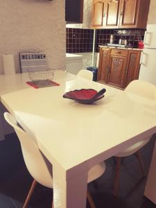 cocina con mesa blanca y sillas blancas en Studio RDC avec terrasse, en Ligny-en-Barrois