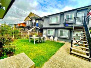 a yard with a table and chairs in front of a house at Charming 1BR near Metrotown DT Burnaby/ Vancouver in Vancouver