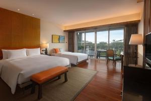 a hotel room with two beds and a balcony at Le Méridien Shimei Bay Beach Resort & Spa in Wanning