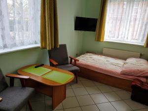 Habitación pequeña con cama, escritorio y mesa. en Sofia, en Dziwnówek
