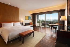 sypialnia z dużym łóżkiem i dużym oknem w obiekcie Le Méridien Shimei Bay Beach Resort & Spa w mieście Wanning