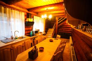 una cocina con mesa y fregadero en una cabaña en Cazare Casa Suw Toplita en Măgheruş