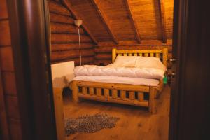 a bed in a room in a log cabin at Cazare Casa Suw Toplita in Măgheruş