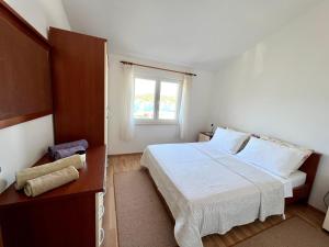 a small bedroom with a bed and a window at Apartment Kustura in Vinišće