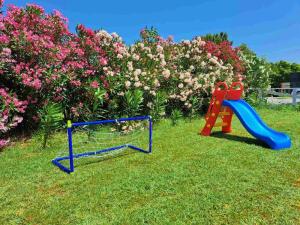 dwa wyposażenie dla dzieci plac zabaw w trawie z kwiatami w obiekcie B&B apartments w mieście Star Dojran