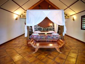 a room with a bed with a canopy at Le Jardin Maore in Kani Keli