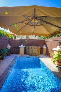 a swimming pool under a large umbrella at Dar 66 Plunge Pool Resort Townhouses in Ras al Khaimah