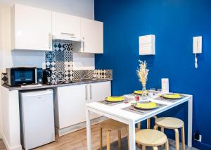 een kleine keuken met een witte tafel en stoelen bij Appartements de caractère centre - WIFI - PARKING in Niort