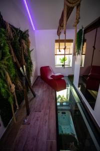 a living room with a red chair and an aquarium at L'Évasion Loveroom in Sarreguemines