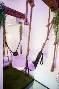 a room with two swings hanging from a wall at L'Évasion Loveroom in Sarreguemines