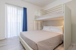 a bedroom with a bed and a bunk bed at Hotel Madera in Lido di Jesolo