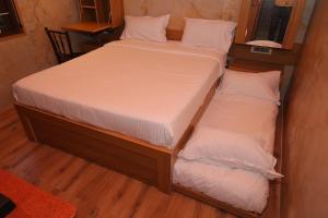 two twin beds in a small room with at The Pear Tree in Yercaud