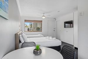 a hotel room with two beds and two tables at Gold Coast Inn in Gold Coast