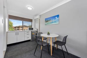 eine Küche und ein Esszimmer mit einem Tisch und Stühlen in der Unterkunft Gold Coast Inn in Gold Coast