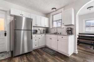 een keuken met witte kasten en een roestvrijstalen koelkast bij Apartments in the Heart of Canton in Canton