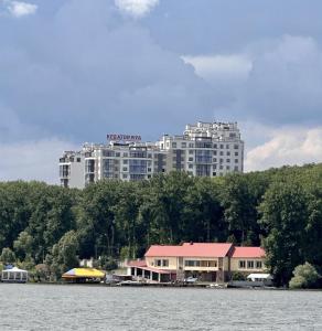 un gran edificio blanco a orillas de un lago en Квартира в парку біля озера, 10 хв до центра, 1км, en Ternopilʼ