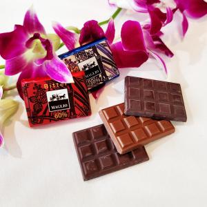 dos trozos de chocolate junto a flores púrpuras en Smart Condo Tomari, en Naha