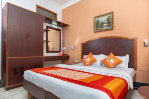 1 dormitorio con 1 cama grande y cabecero de madera en Collection O 5377 Hotel Raaj Bhaavan, en Chennai