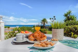 ein Tisch mit einem Teller Essen und einem Glas Orangensaft in der Unterkunft Adosada con jardín y piscina con acceso al mar - DOÑA LOLA in Sitio de Calahonda
