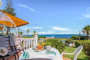ein Tisch auf einem Balkon mit Blick auf das Meer in der Unterkunft Adosada con jardín y piscina con acceso al mar - DOÑA LOLA in Sitio de Calahonda