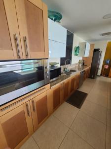 una cucina con armadietti in legno ed elettrodomestici in acciaio inossidabile di Peninsula Condominiums, Hotel Zone, PV a Puerto Vallarta Altre 3 foto