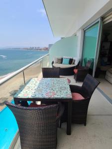 un tavolo e sedie sul balcone di una nave da crociera di Peninsula Condominiums, Hotel Zone, PV a Puerto Vallarta