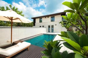- une piscine avec une chaise et un parasol à côté d'une maison dans l'établissement Le Méridien Shimei Bay Beach Resort & Spa, à Wanning
