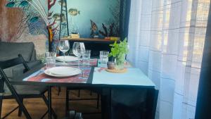 a table with plates and wine glasses on it at бутиков апартамент Деси in Pomorie